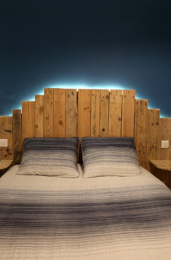 Lit En Palettes Avec L'éclairage Derrière La Tête De Lit