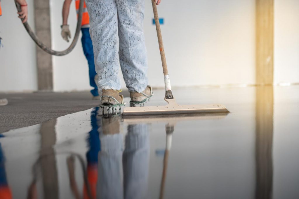 Istock Homme applicant du béton au sol