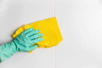 Main avec gant lave le carrelage