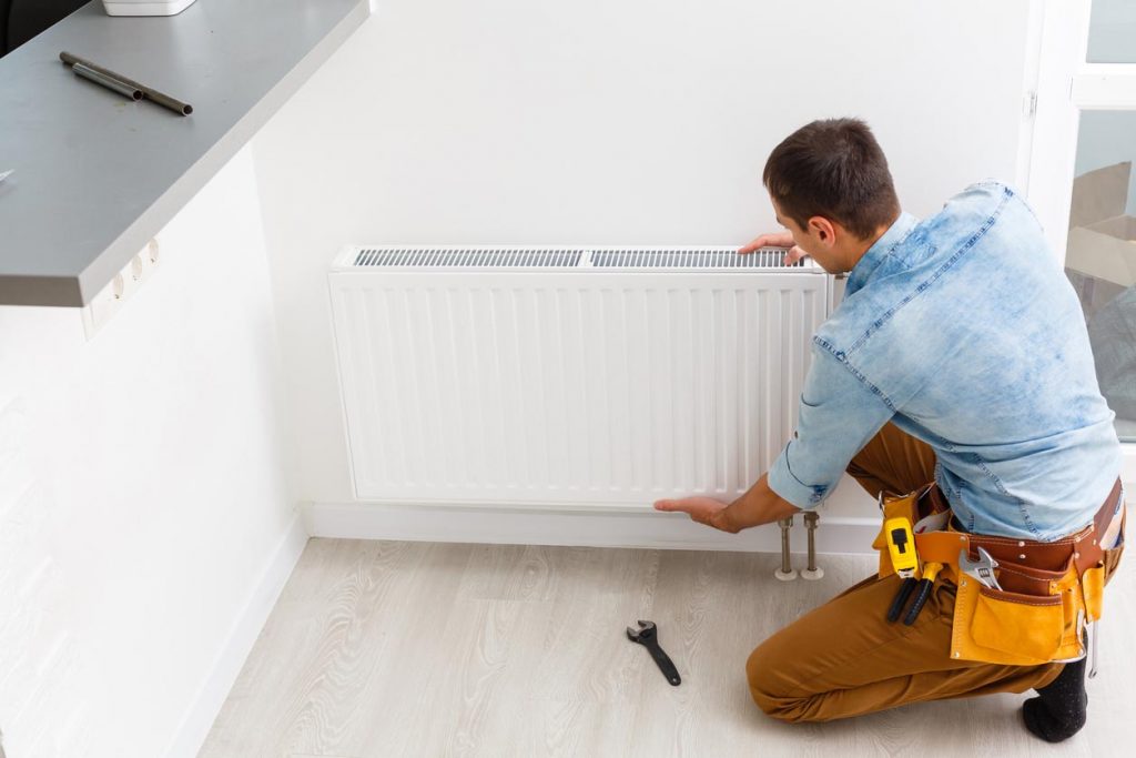 Un rpfessionnel installe le nouveau radiateur
