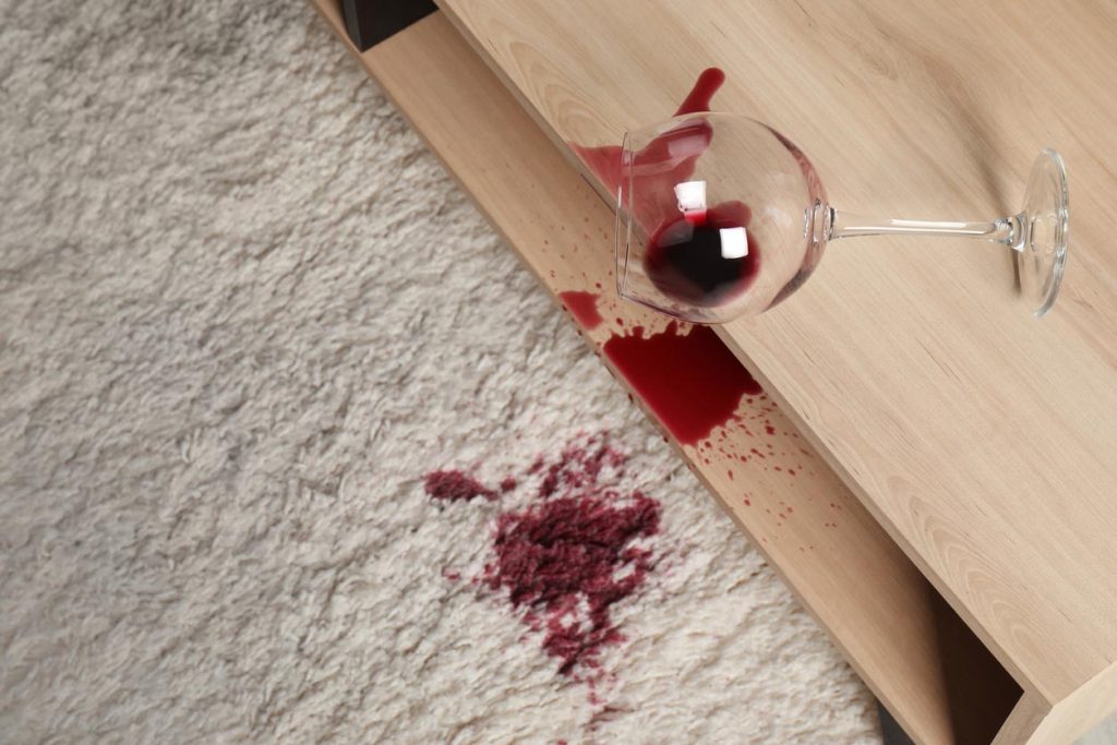 Verre de vin renversé sur tapis beige