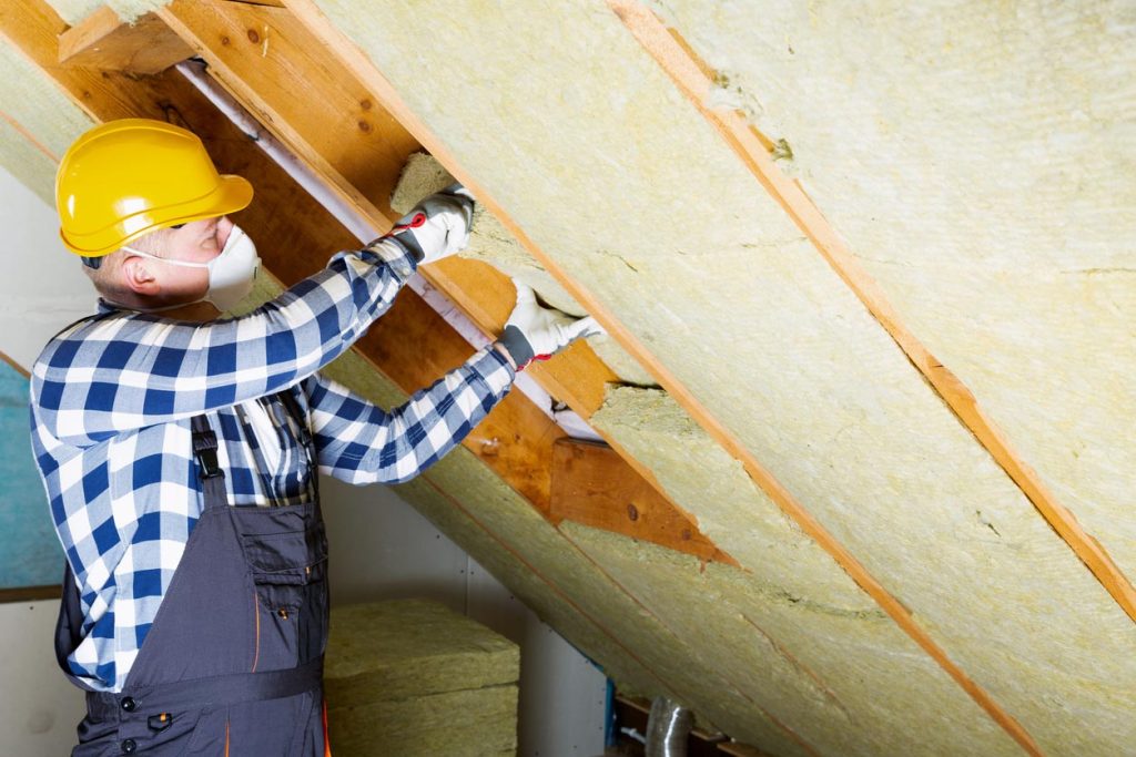 Homme faisant l'isolation d'une maison en bois