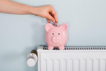 Concept d'économie sur le chauffage avec une tirelire sur le radiateur