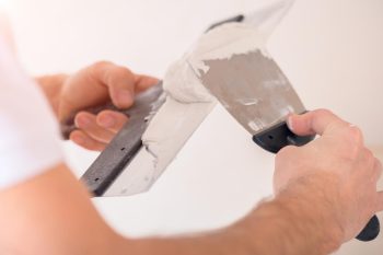 Homme applique du Tadelakt sur sa spatule