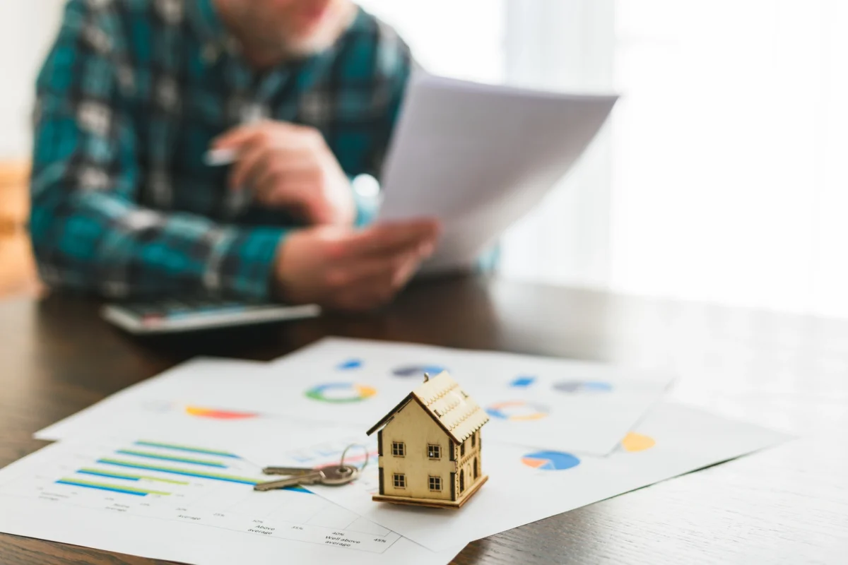 Un investisseur immobilier analyse ses documents financiers pour estimer ses revenus locatifs