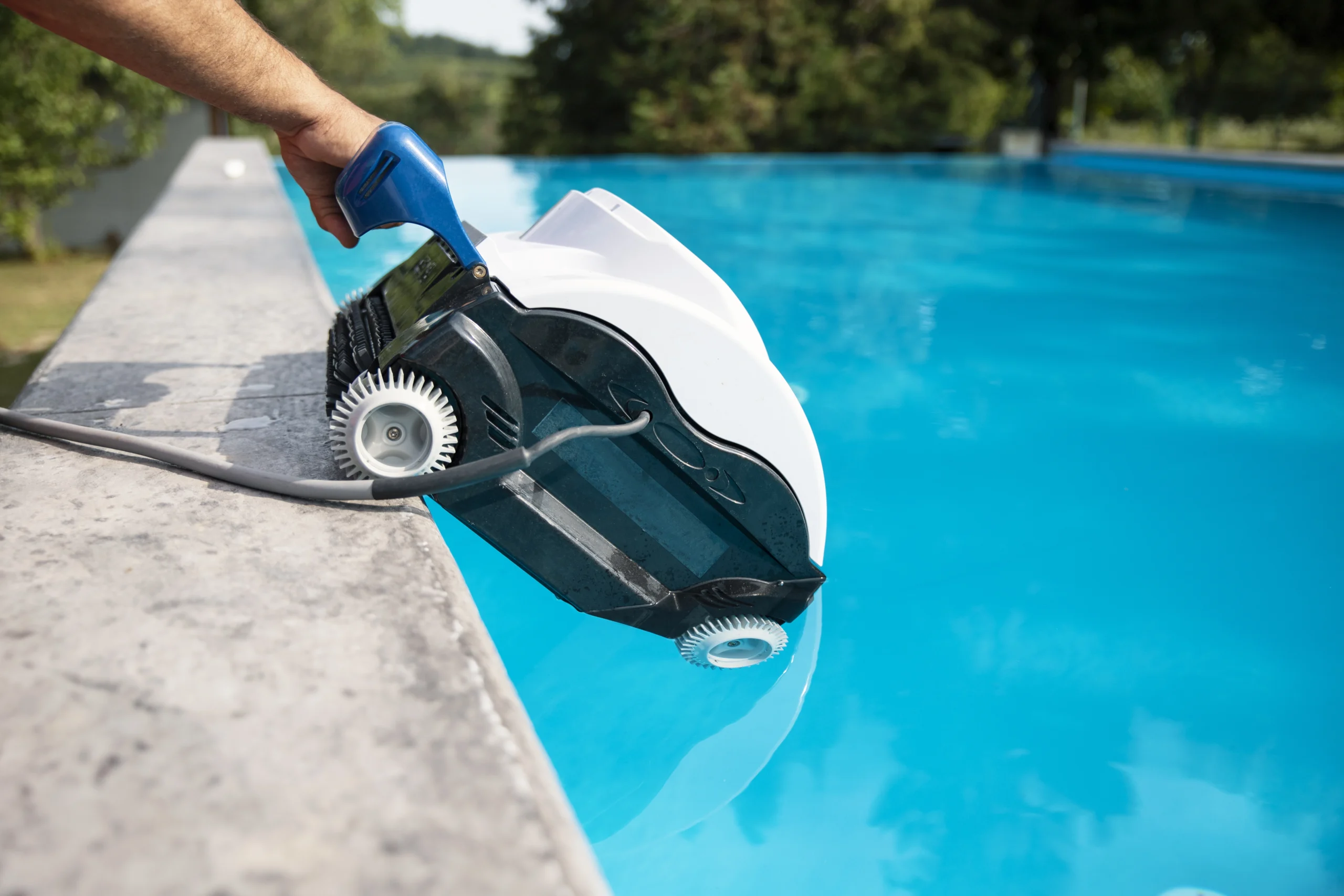 Robot piscine automatique posé au bord d’un bassin prêt à nettoyer
