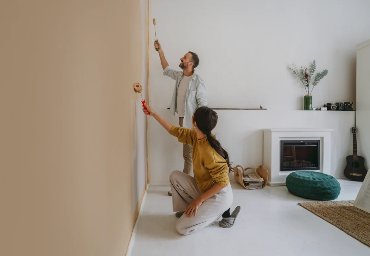 Un couple peint un mur ensemble pendant la rénovation de la maison